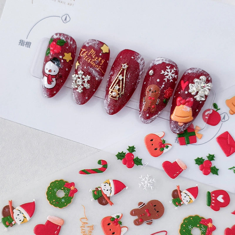 Christmas nail stickers with snowman, gingerbread man and bell applied on red nails – festive holiday nail art