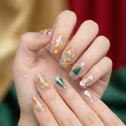 Christmas nail stickers applied on nails with snowman, gingerbread and Christmas tree – festive holiday manicure