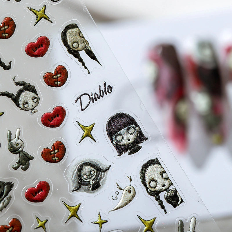 gothic nail art stickers, including a pigtailed girl, a weird rabbit, red damaged hearts, golden stars, and the word "Diablo", with a grotesque and artistic style